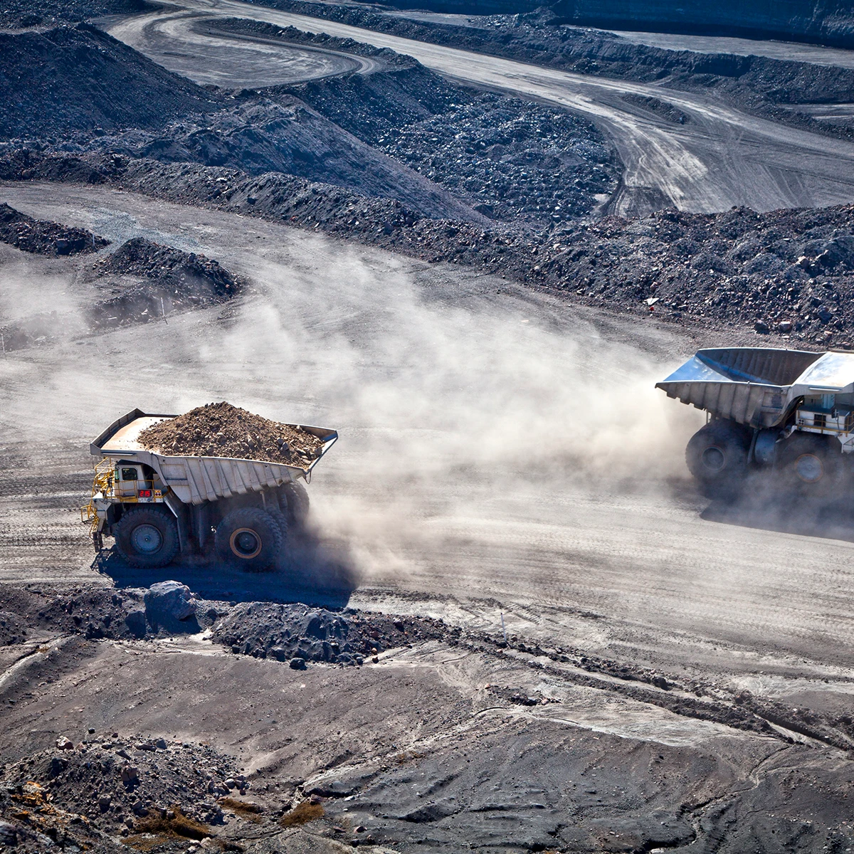 Dump truck carriers a full load along a dirt road in a New Zealand coal mine.