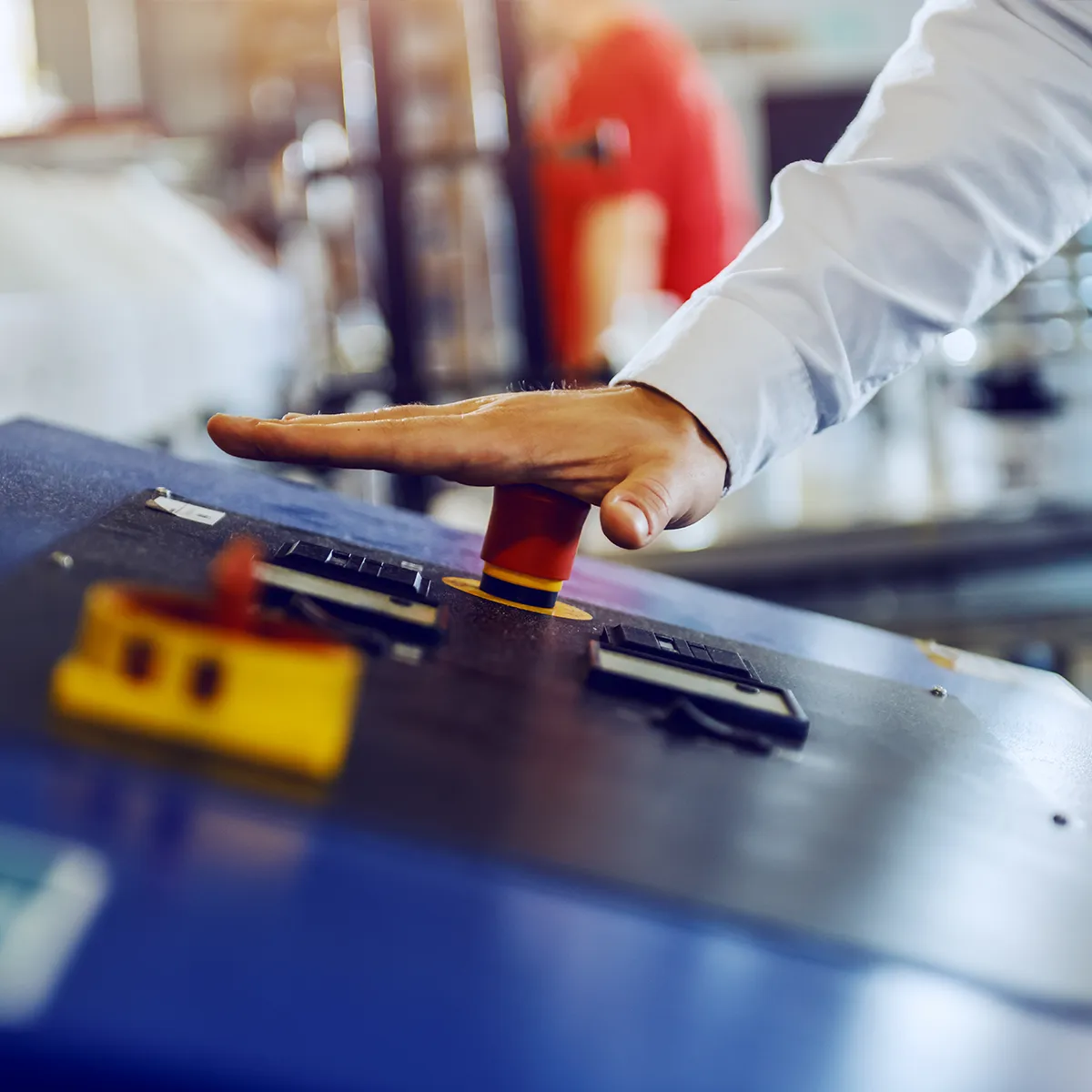 Industrial facility worker goes to press the emergency stop button installed by CSE WAF