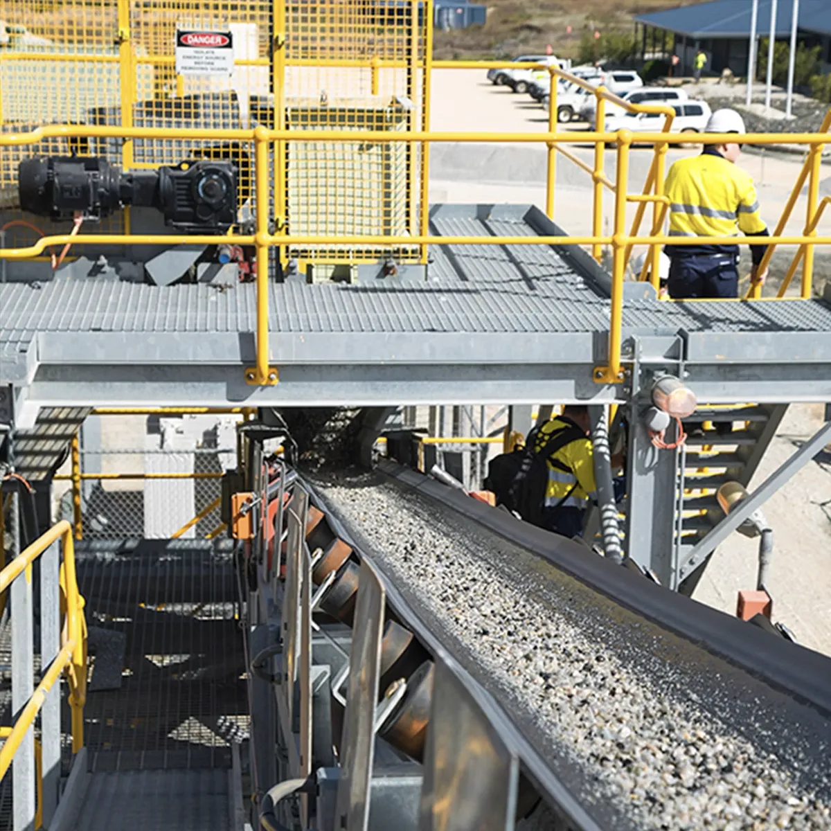 Mining operator checks on a conveyor belt transporting iron ore.