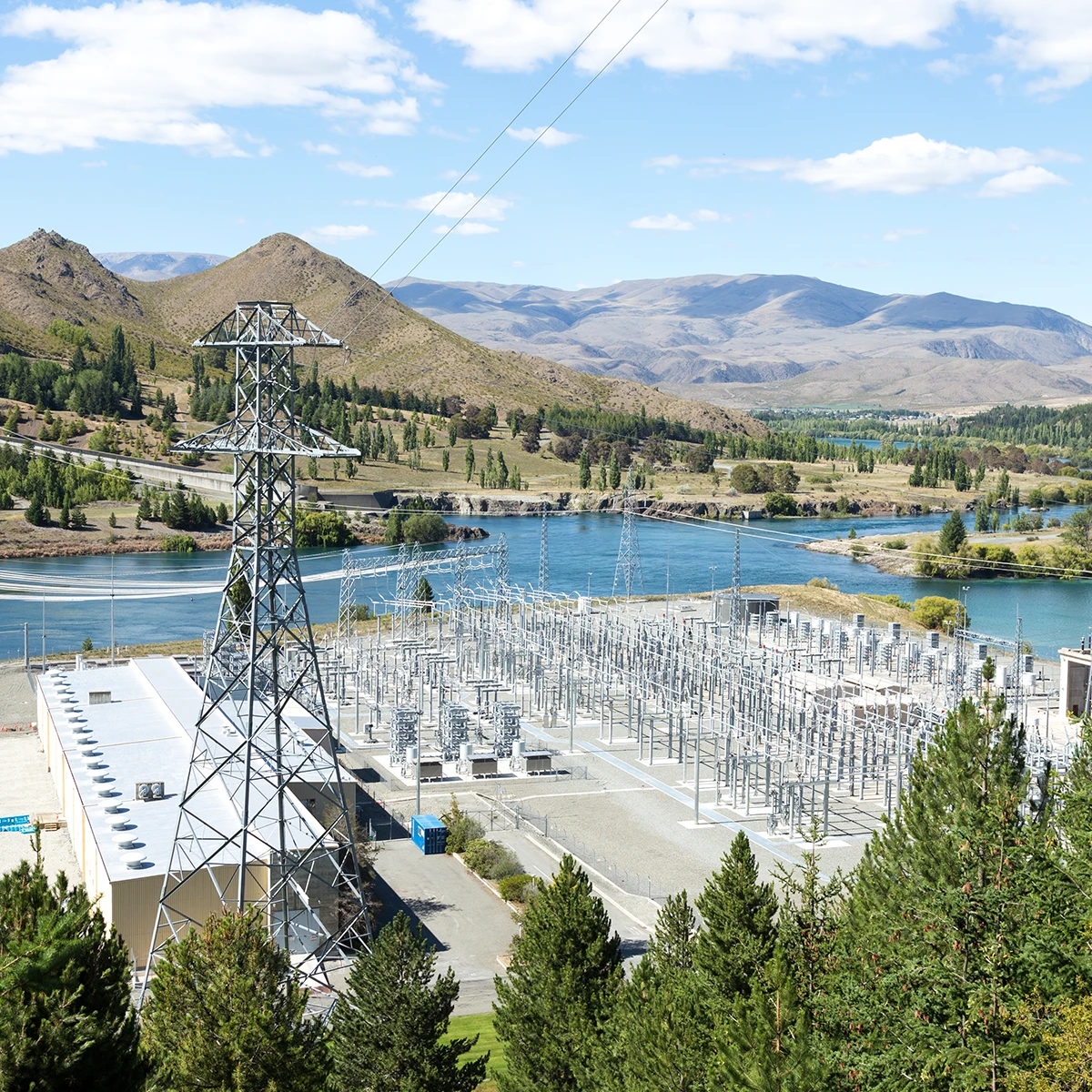 New Zealand electric substation next to a dam on a bright, sunny day